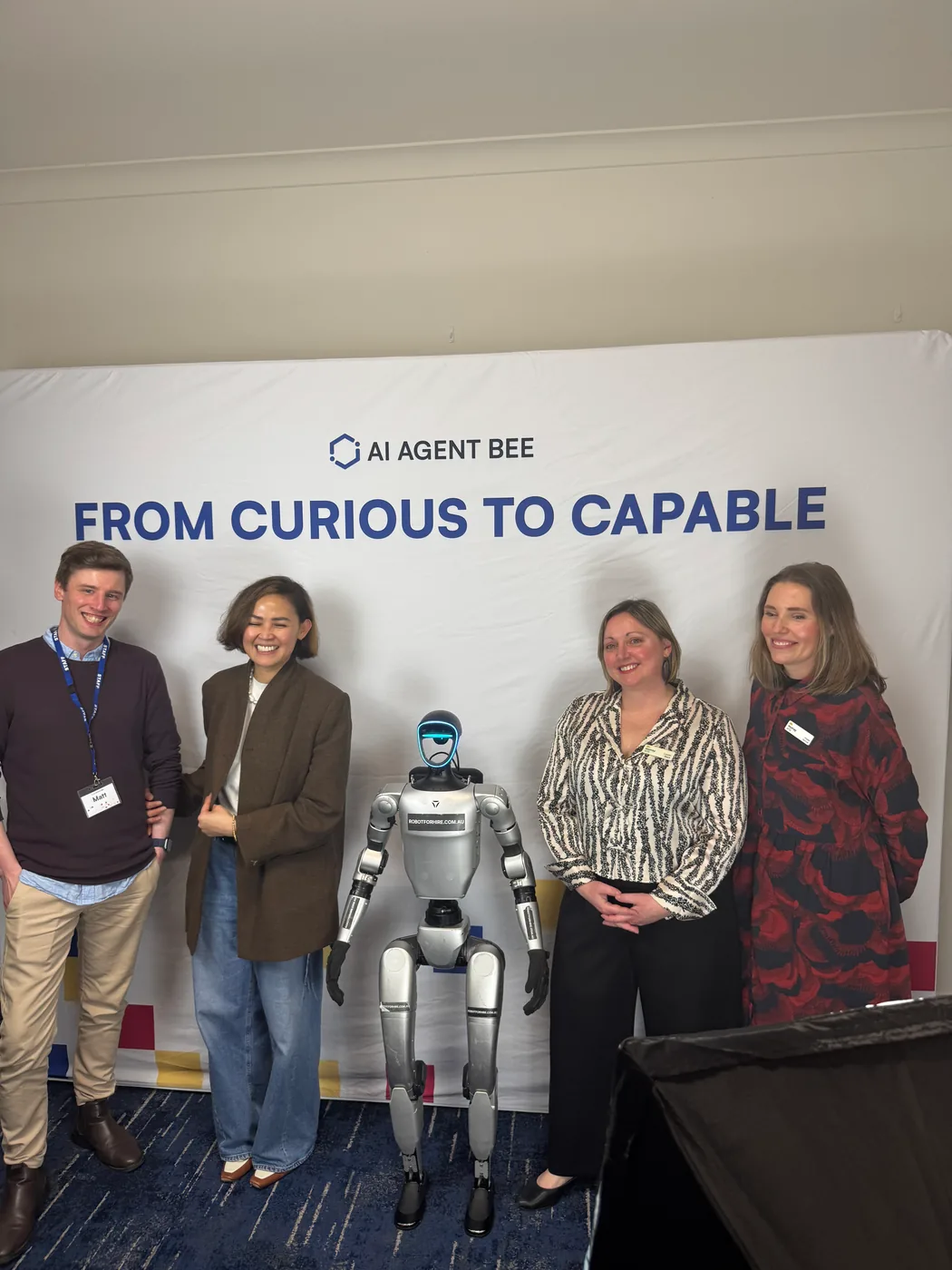 Guests posing with Rocco at the AI Agent Bee launch backdrop
