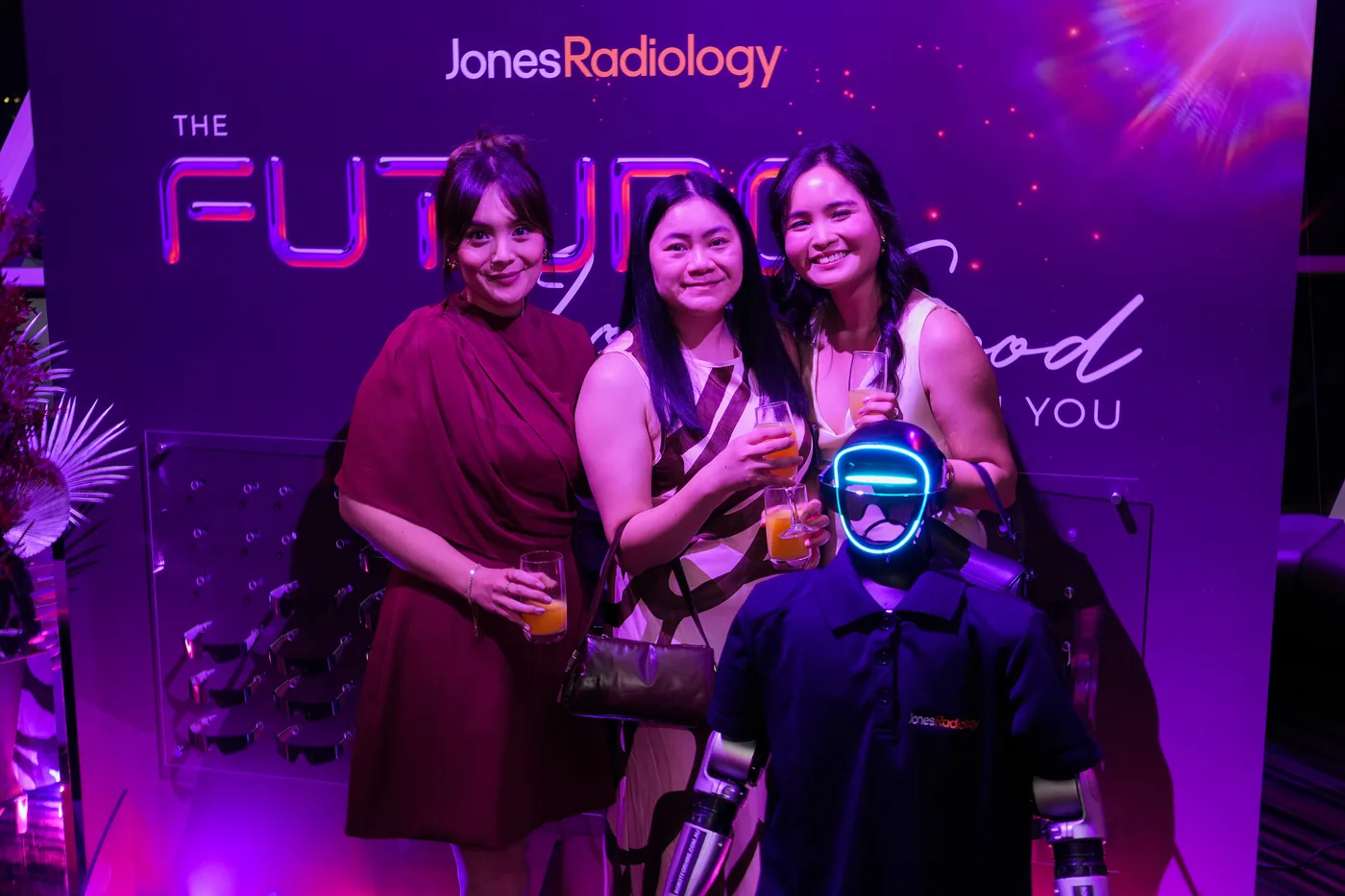 Three Jones Radiology guests with Rocco in a Jones Radiology shirt at The Future Looks Good On You backdrop