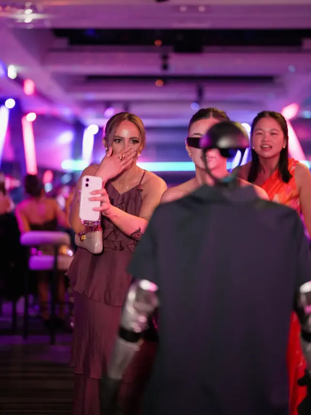 Guests reacting to Rocco humanoid robot at an evening event